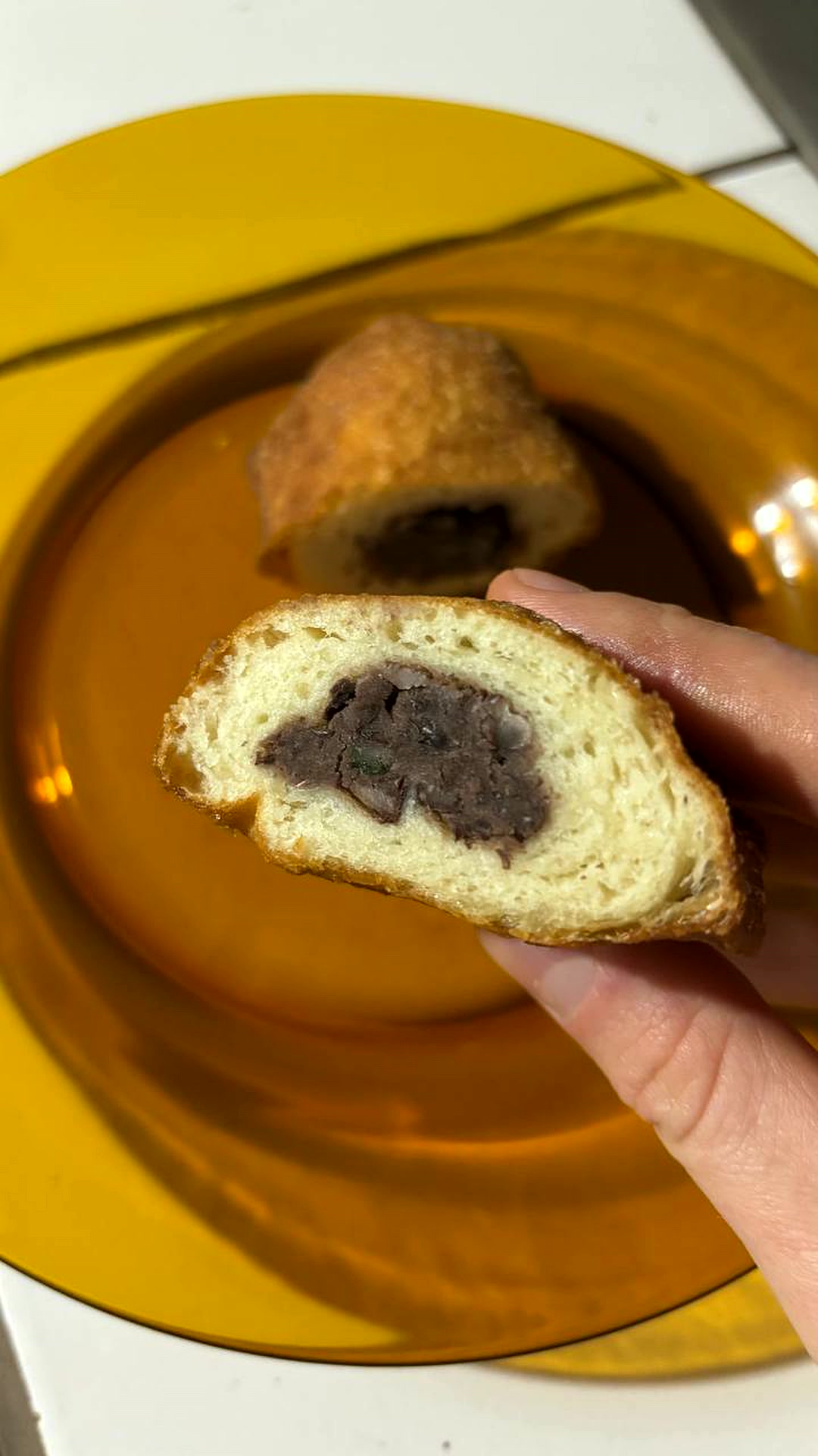 Pierogi de feijão cortado ao meio, mostrando a massa fofa tipo pão e o recheio de feijão